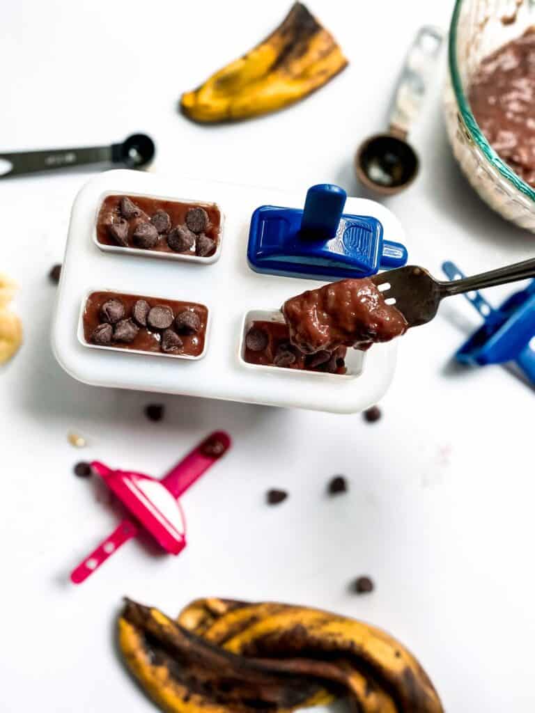 spooning the chocolate mixture into popsicle molds with a fork