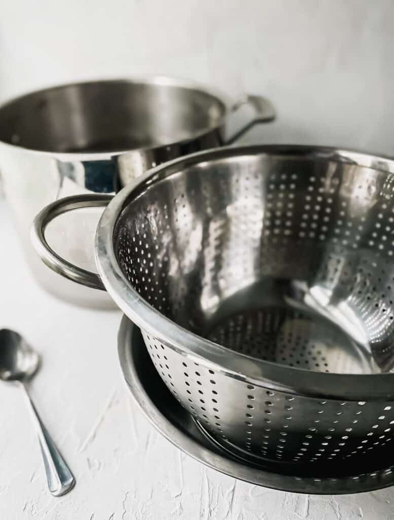metal colander inside a metal bowl