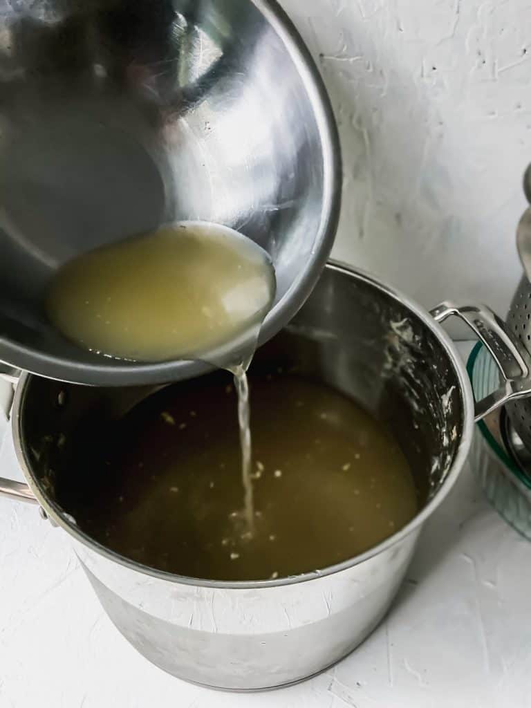 pouring juices from the vegetables back into the soup broth
