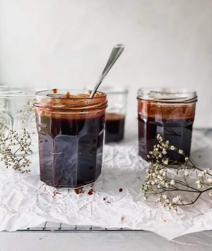 pomegranate bbq sauce in a jar with a spoon