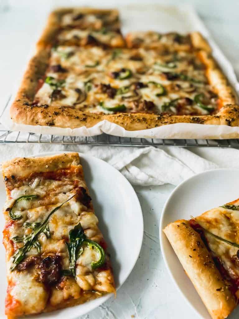 cooked no knead pan pizza dough in mushroom, sausage, and arugula pizza